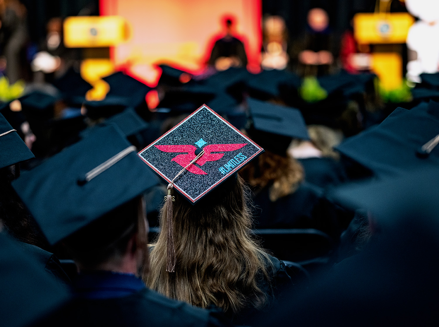 An undergraduate student with a decorated grad cap at the commencement ceremony